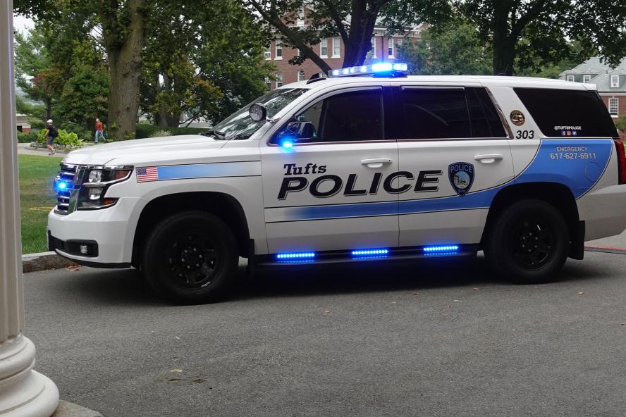 Tufts University Police Department vehicle with the lights on