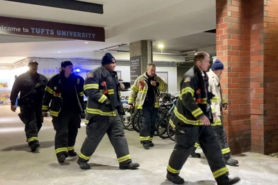 Firemen and women walking inside a Tufts building